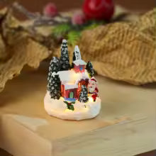 casinha de natal vermelha iluminada com pinheiros