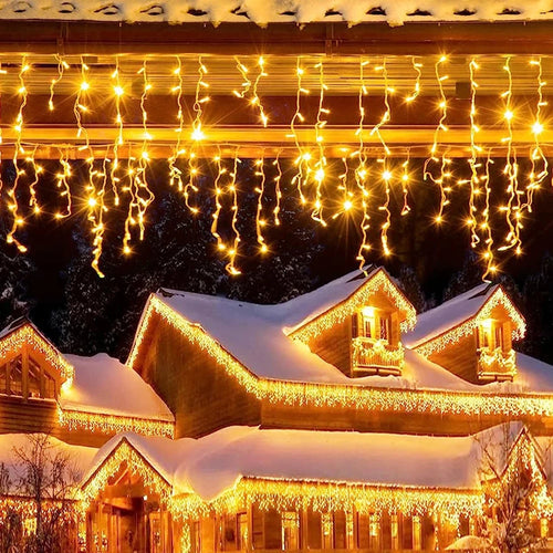 cascata de natal em franja iluminando beiral de casa com neve