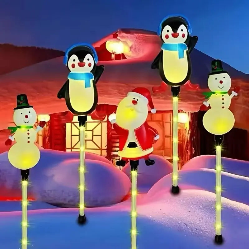 estacas solares pinguim papai noel e boneco de neve acesas