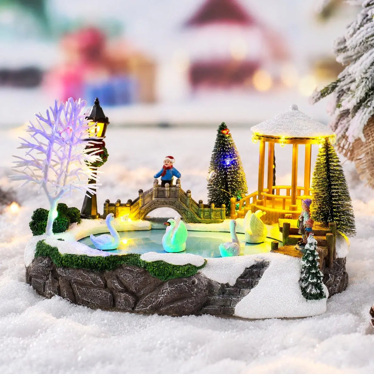 vila de natal lago dos cisnes iluminada com coreto e ponte na neve